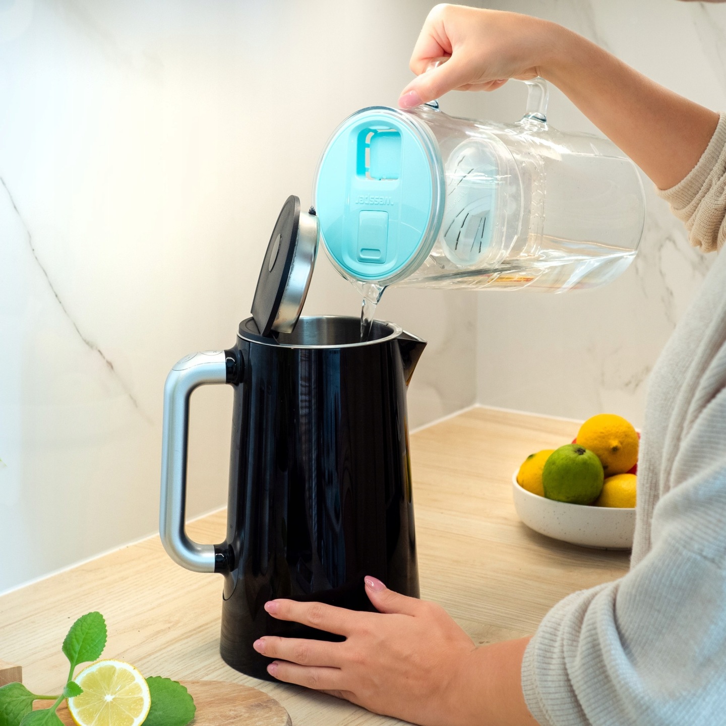 Zastosowanie przefiltrowanej wody z&nbsp;dzbanka Wessper futureflow - kobieta nalewa wodę do czajnika